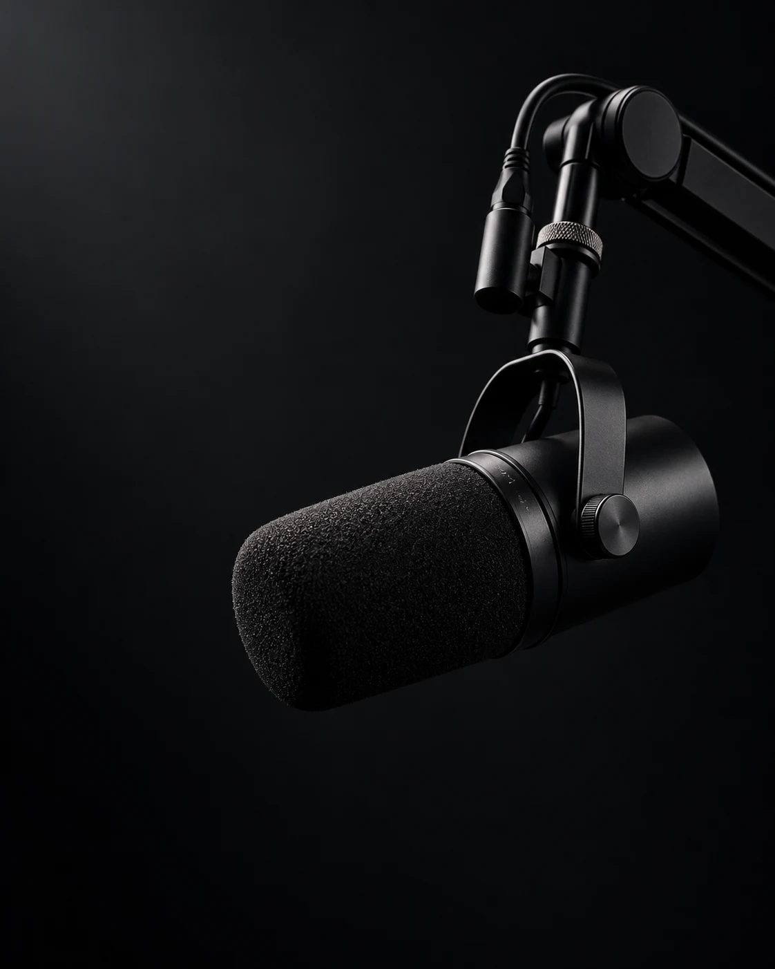 Close-up of a podcast microphone in a dark recording studio